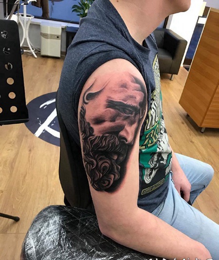 男子右手大臂上的黑灰色人物肖像纹身图片