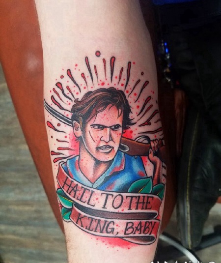 手臂上的拿枪的男子和英文横幅纹身图片