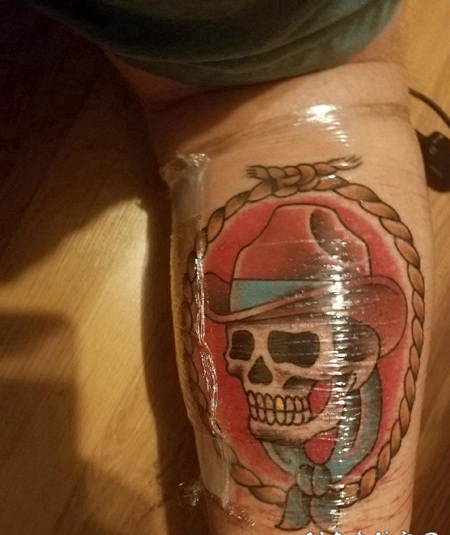 小腿上的绳子和牛仔帽和骷髅头纹身