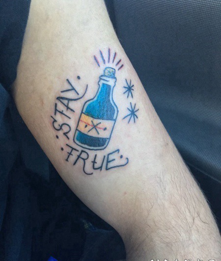 大臂上的一个玻璃瓶子和英文字纹身