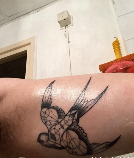 手大臂上的几何风格黑色燕子纹身