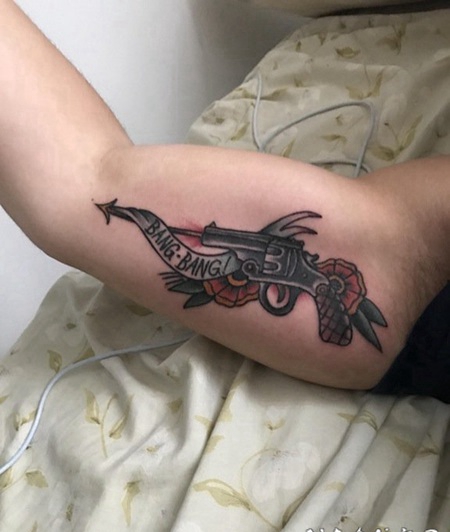 手大臂内侧的手枪箭和花朵纹身