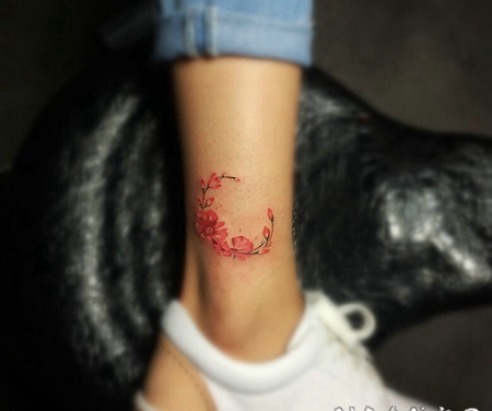 小腿处月亮式的彩色花朵纹身图案