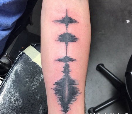 手臂上的黑色声波图案纹身