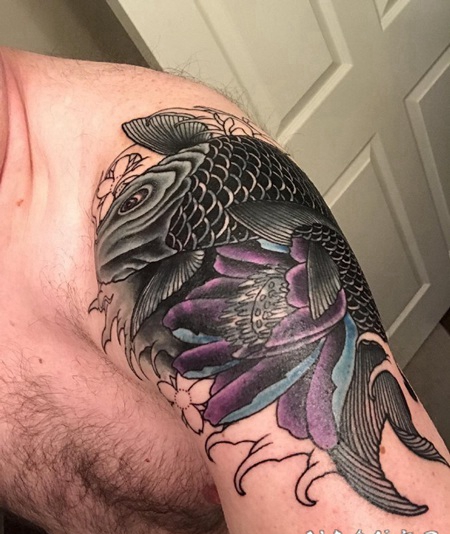 男子肩膀上的大黑色鲤鱼和蓝紫色莲花纹身