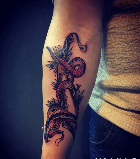 手臂毒蛇缠绕匕首个性纹身图片
