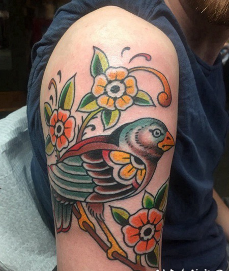 男性右手臂上彩色的鸟纹身小花朵纹身图片