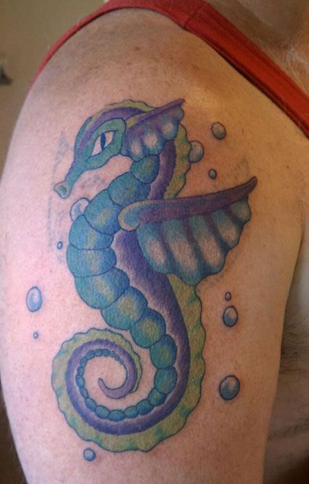 大臂上的蓝色海马纹身图案