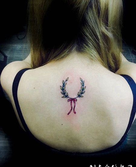 女子后背蝴蝶结花带纹身图案