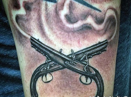 插画风格的黑色交叉手枪手臂纹身图案