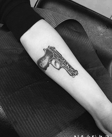 手臂黑灰手枪纹身图案