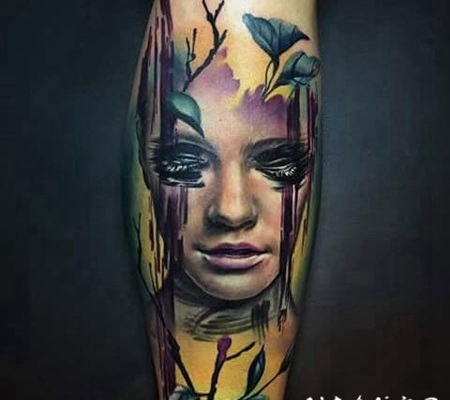 手臂彩色的女性肖像与树叶纹身图案