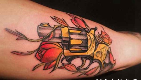 手臂彩色的小手枪与花朵纹身图案