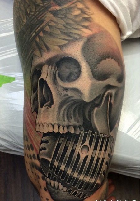 手臂灰色的骷髅与麦克风纹身图案