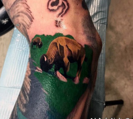 手臂五彩草原吃草的牛纹身图案