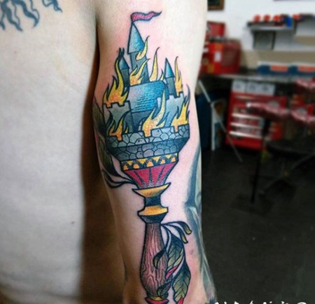 手臂彩色的火炬与燃烧城堡纹身图案