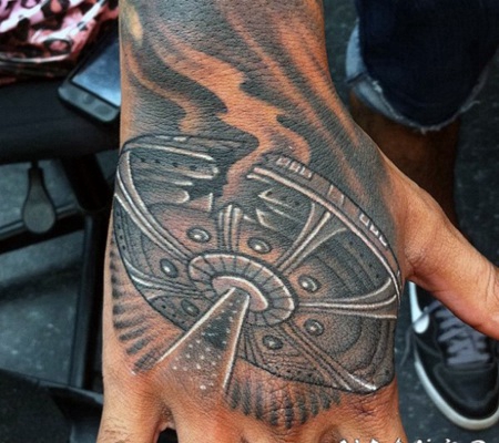 手背漫画风格黑色损坏的飞碟纹身图案