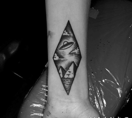 手腕微小的黑色飞船与金字塔纹身图案