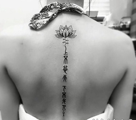 女生背部黑色莲花与字符纹身图案