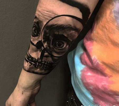 令人毛骨悚然的骷髅和放大镜手臂纹身图案