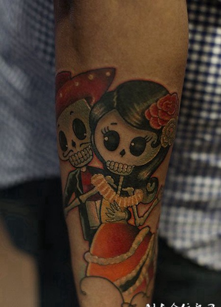 手臂上的Q版骷髅娃娃纹身图案