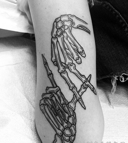 手臂简单的黑色线条骷髅手纹身图案