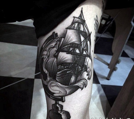 手臂雕刻风格的黑色地球仪与帆船纹身图案