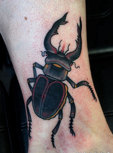 脚踝上的深色昆虫纹身图案