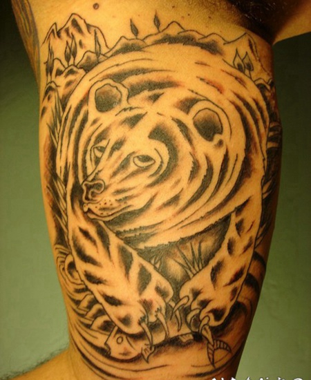 手臂黑色的熊捕捉鲑鱼纹身图案