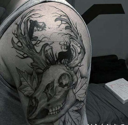 手臂不寻常的黑色鹿头骨与树叶纹身图案