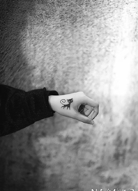 手腕上一只可爱的猫纹身图案