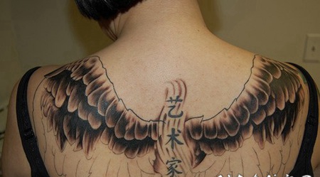 背部黑色的翅膀与汉字纹身图案