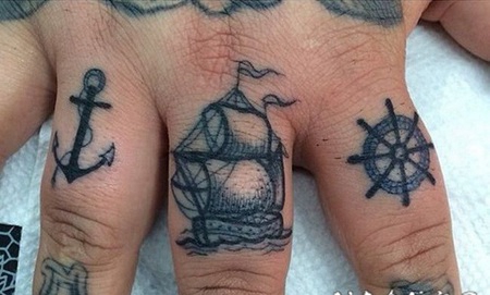 手指黑色的船锚和帆船与船舵纹身图案