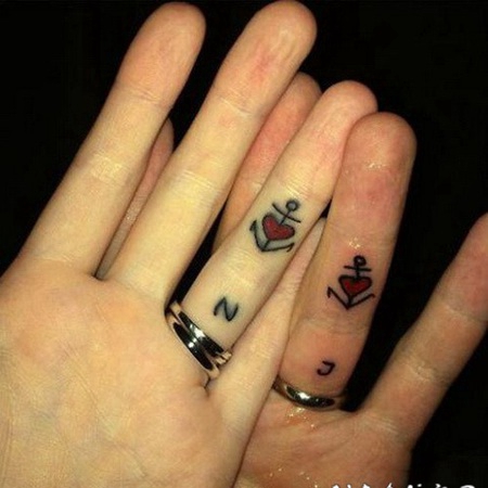 情侣手指黑色的船锚和红色心形纹身图案