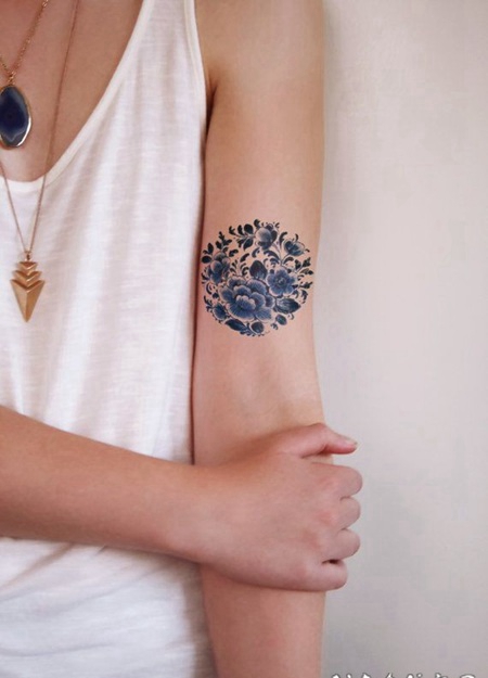 女孩手臂令人惊讶的深蓝色花朵纹身图案