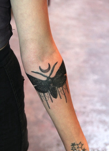 手臂黑色的小飞蛾纹身图案