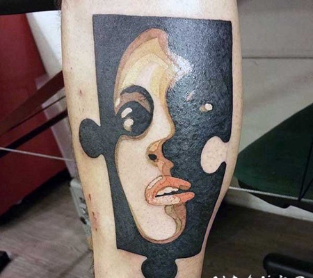 小腿彩色的拼图块与女人肖像纹身图案