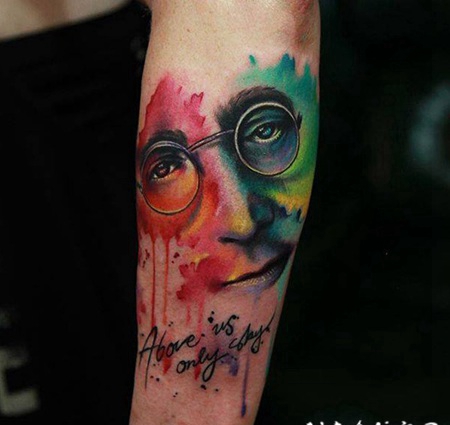 手臂彩色的列侬肖像和字母纹身图案