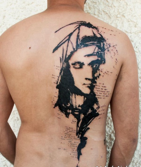背部黑色的女人脸和字母纹身图案