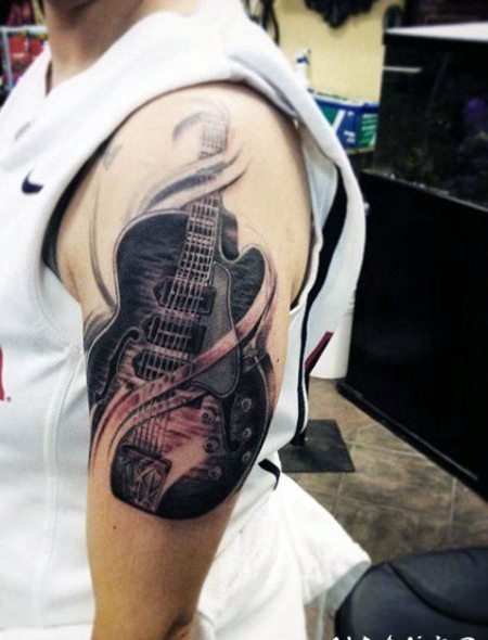 大臂3D写实的黑色吉他纹身图案