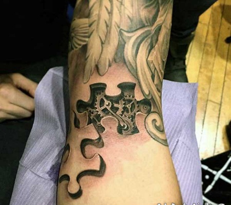 手臂黑色的3D拼图与机械小零件纹身图案