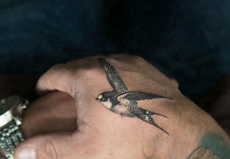 手背虎口处一只飞翔的燕子纹身图案