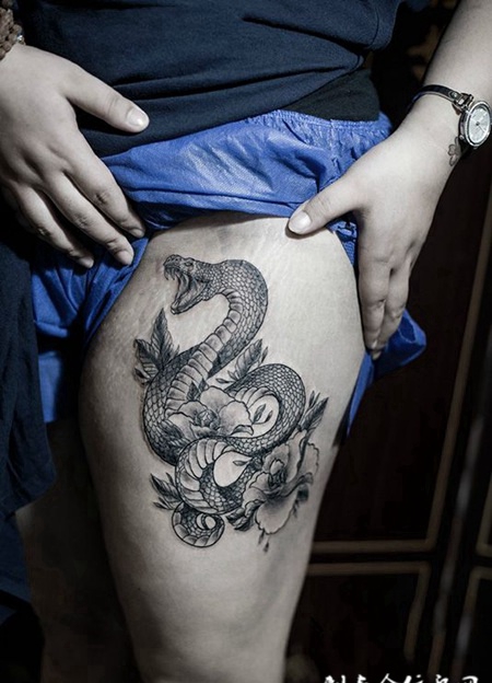 灵蛇戏花间，大腿蛇与鲜花创意纹身