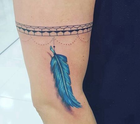 牙齿形状的臂环和蓝色羽毛纹身图案