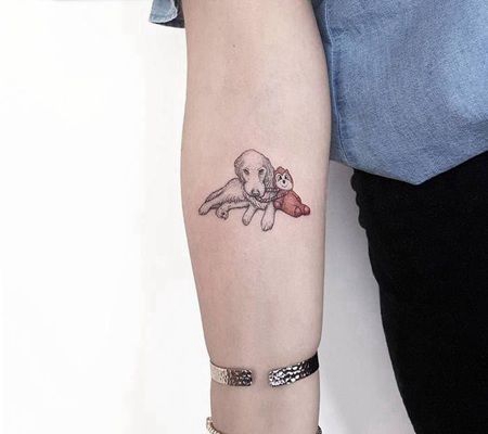 手臂上可爱的金毛狗和它的玩具纹身