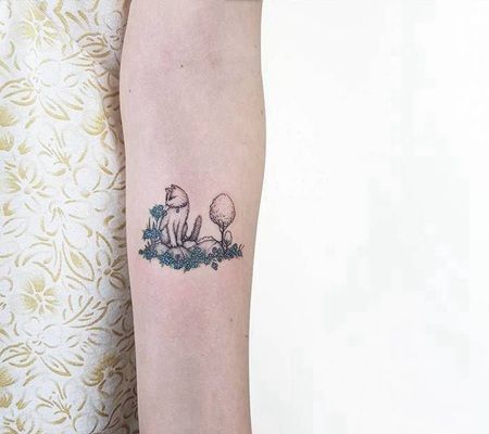 可爱的小猫咪坐在石头上发呆的纹身图片