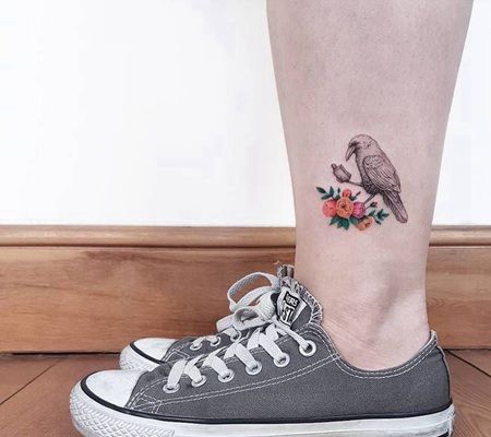 小腿处爪子握着东西的乌鸦和花纹身图