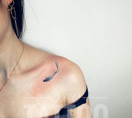 美女锁骨处一条浅蓝色的优美金鱼纹身图案