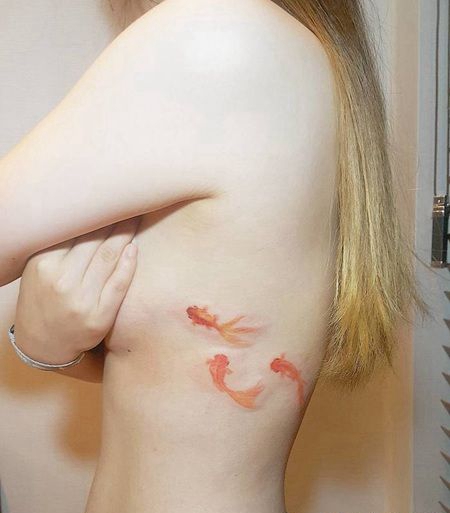 美女肋骨部位唯美的三条红寿金鱼纹身图案
