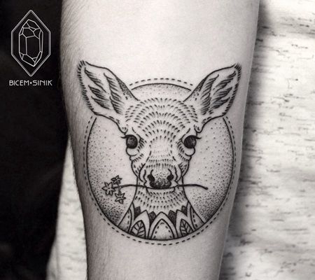 圆圈里面一直小动物咬着一枝花的点刺纹身图案